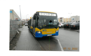 Na zdjęciu widzimy autobus MZK, z napisem : 16, odjazd za 3 min; w tle budynki i samochody osobowe